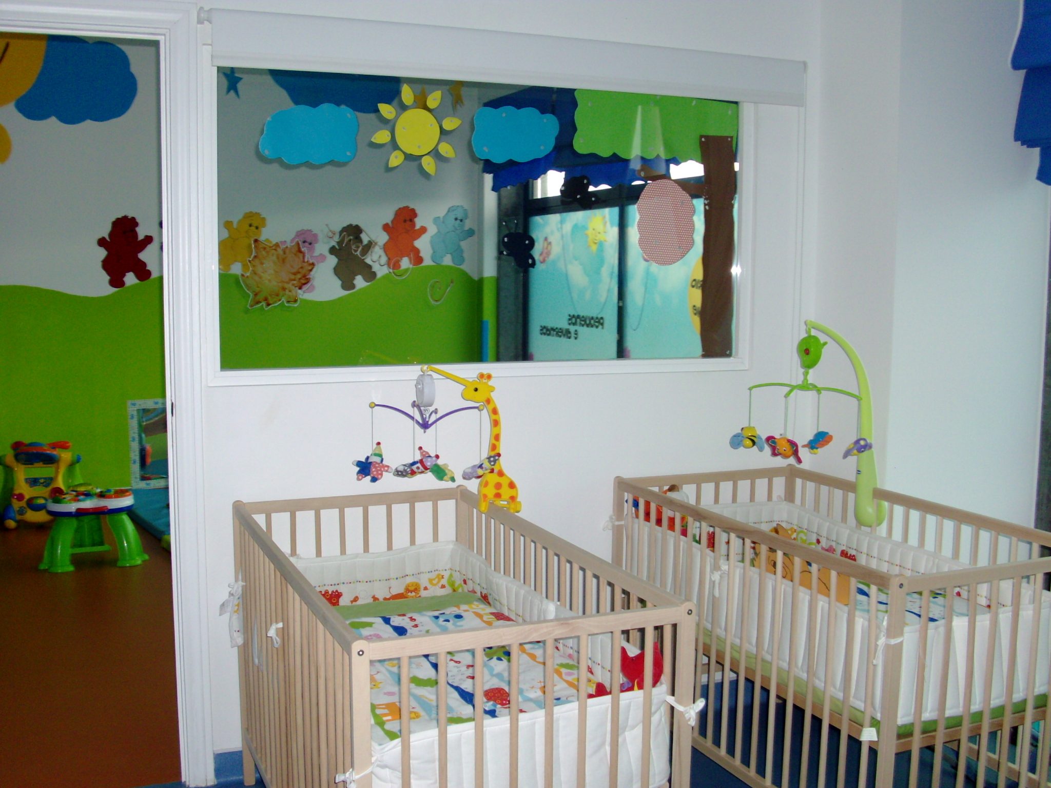 Nursery room with two cribs and colorful decorations