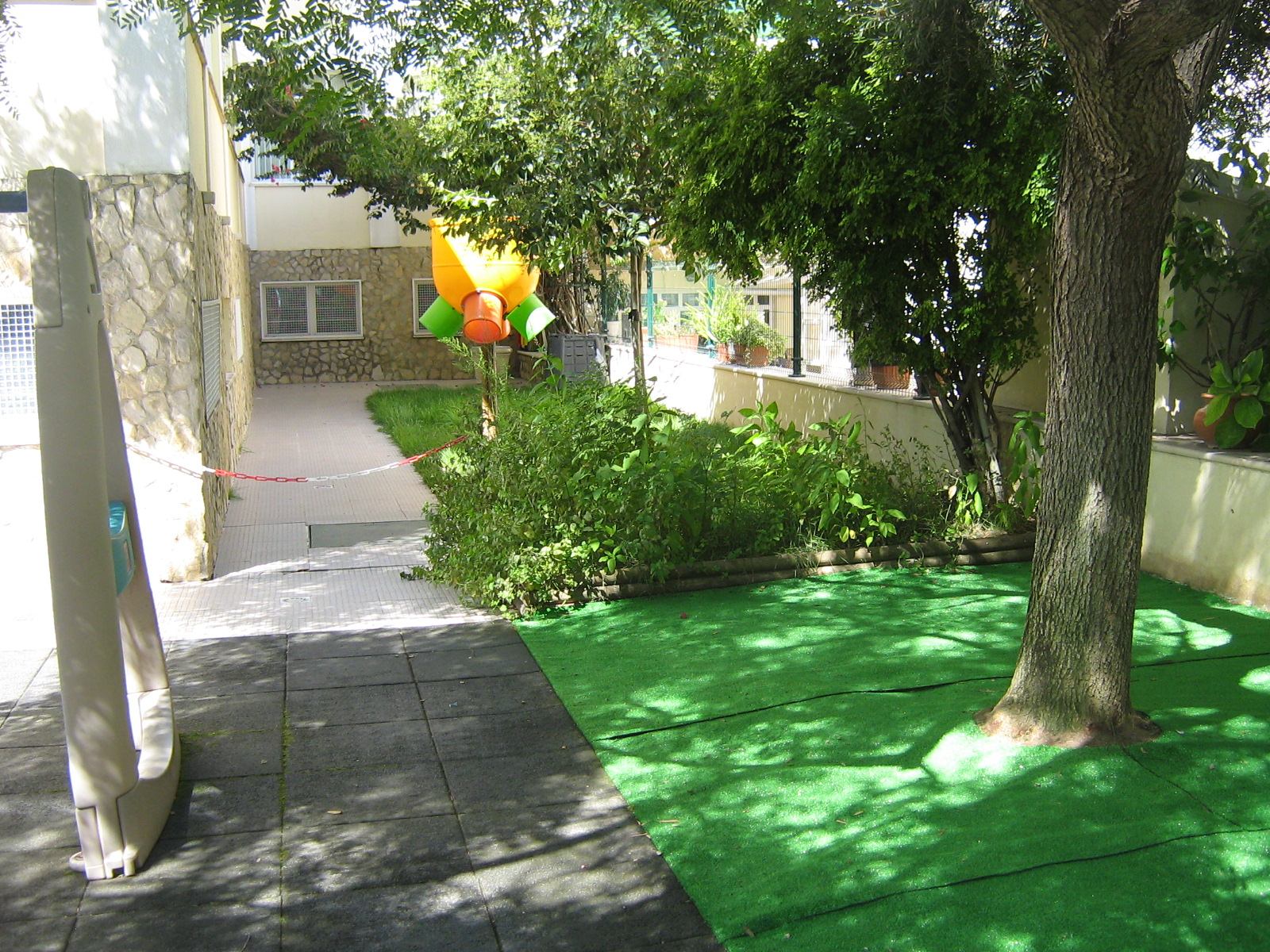 Preschool playground with artificial turf and a tree