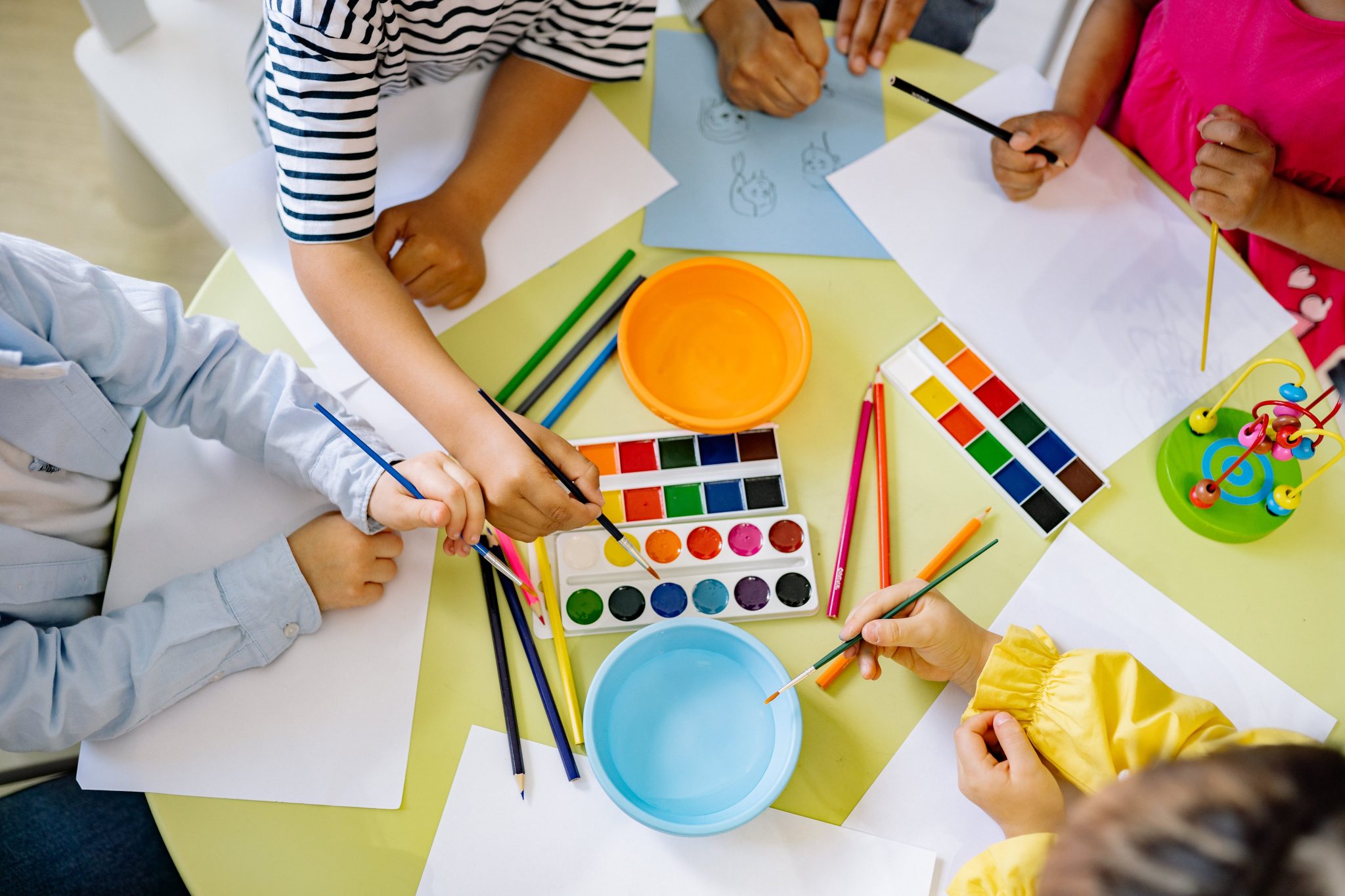 Preschool children painting and drawing at a table