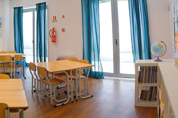 Preschool classroom with tables, chairs, and bookshelves