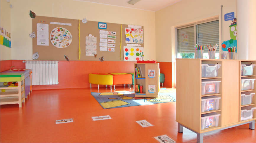 Preschool classroom with colorful furniture, bookshelves, and educational materials