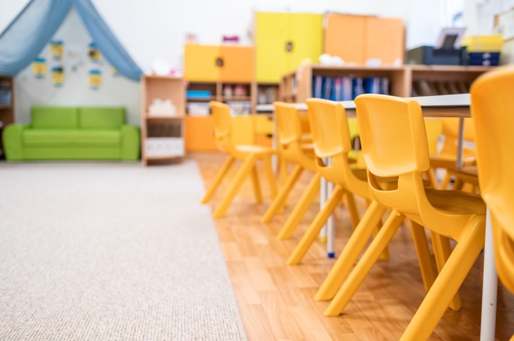 Empty classroom with yellow chairs and colorful storage units