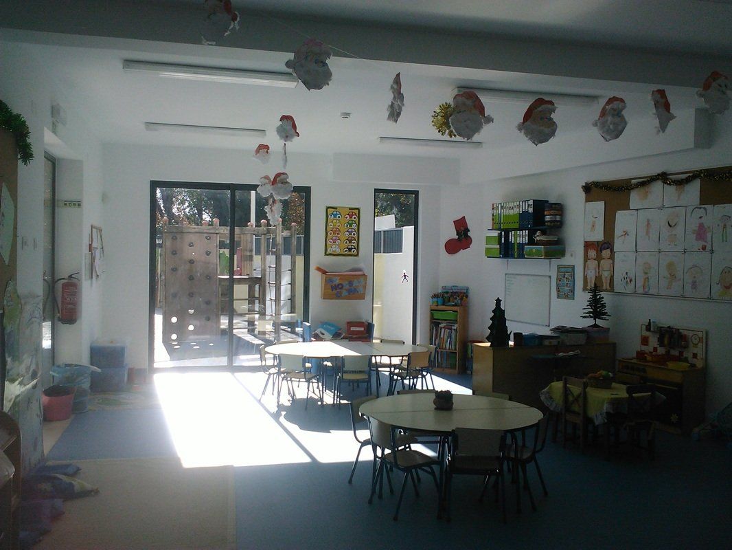 Preschool classroom with tables, chairs, and children's artwork