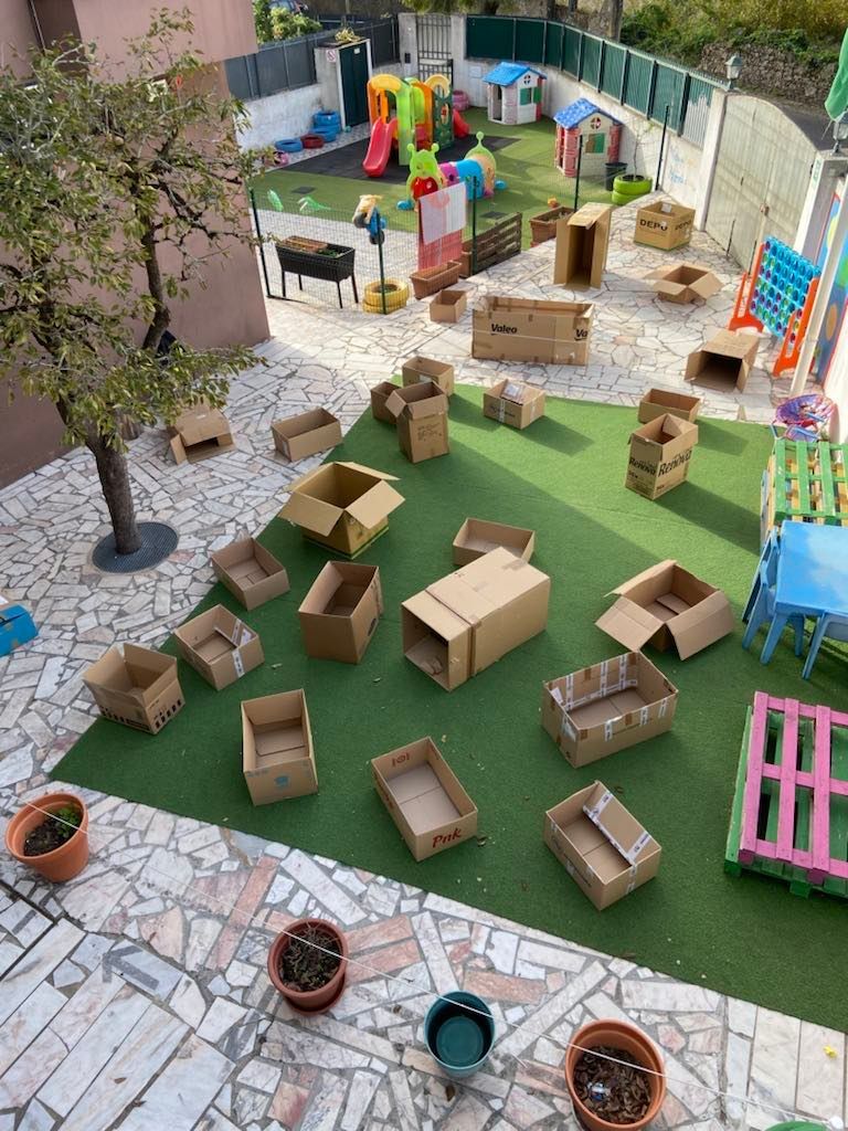 Preschool children's playground with cardboard boxes used creatively for play