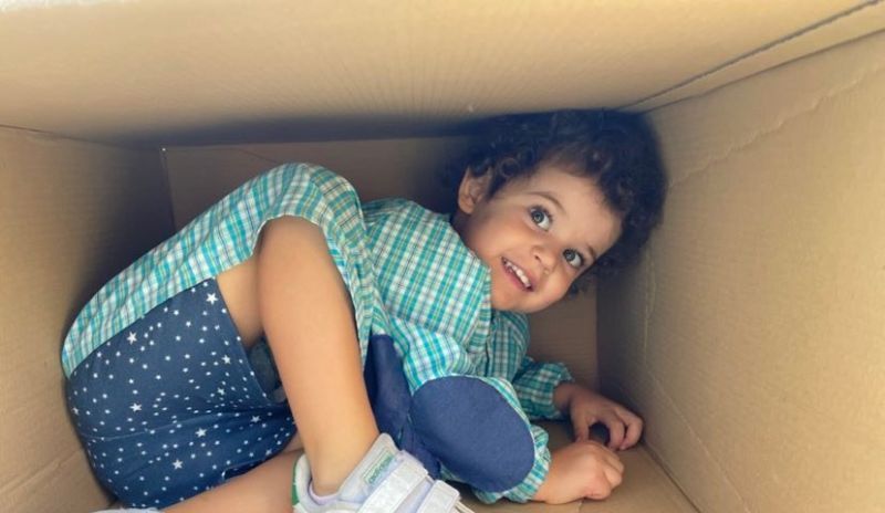 Preschool child playing creatively in a cardboard box