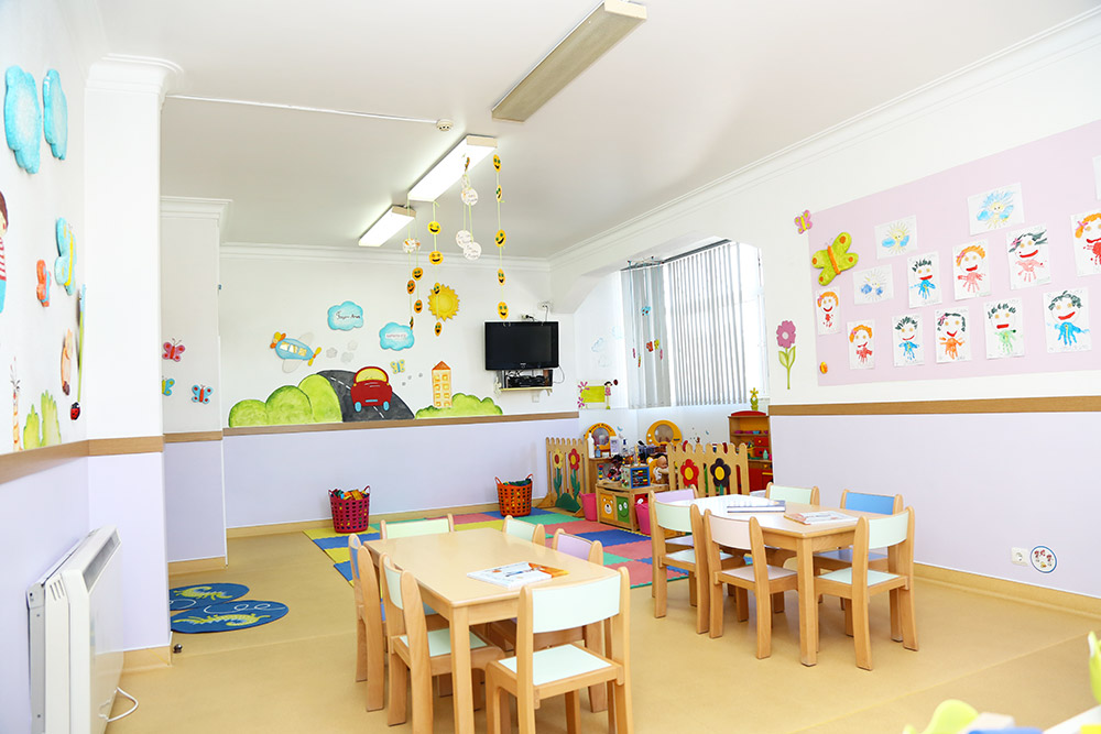 Preschool classroom with colorful decorations and small tables and chairs