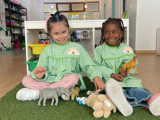 Two preschool children playing with toy animals at Colegio Os Meus Amigos
