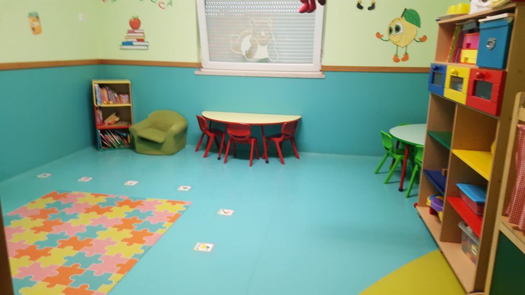 Preschool classroom with colorful furniture and play area