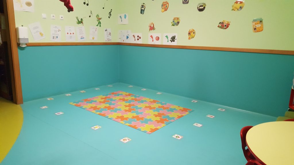 Preschool classroom with colorful puzzle mat and educational wall decorations