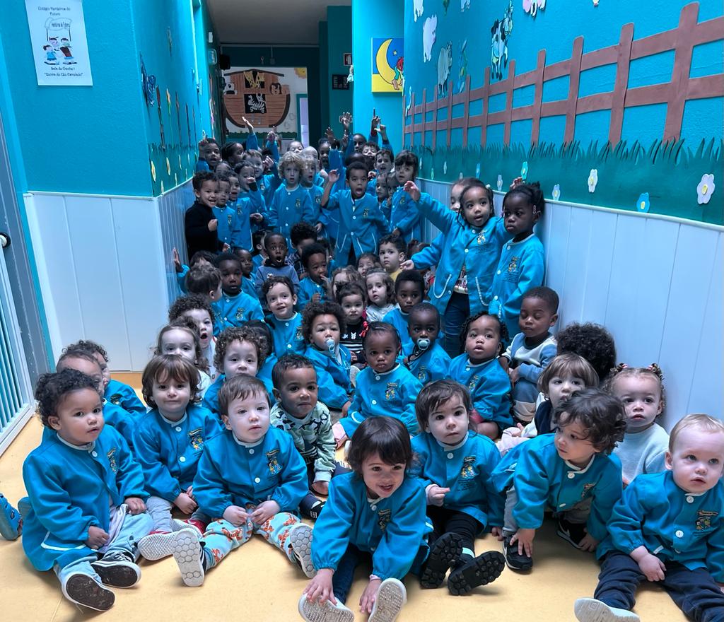 Group photo of preschool children in blue uniforms at Colégio Herdeiros Do Futuro