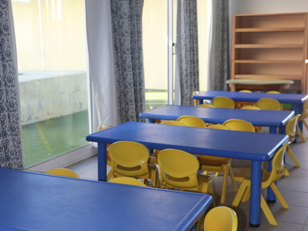 Preschool cafeteria with blue tables and yellow chairs