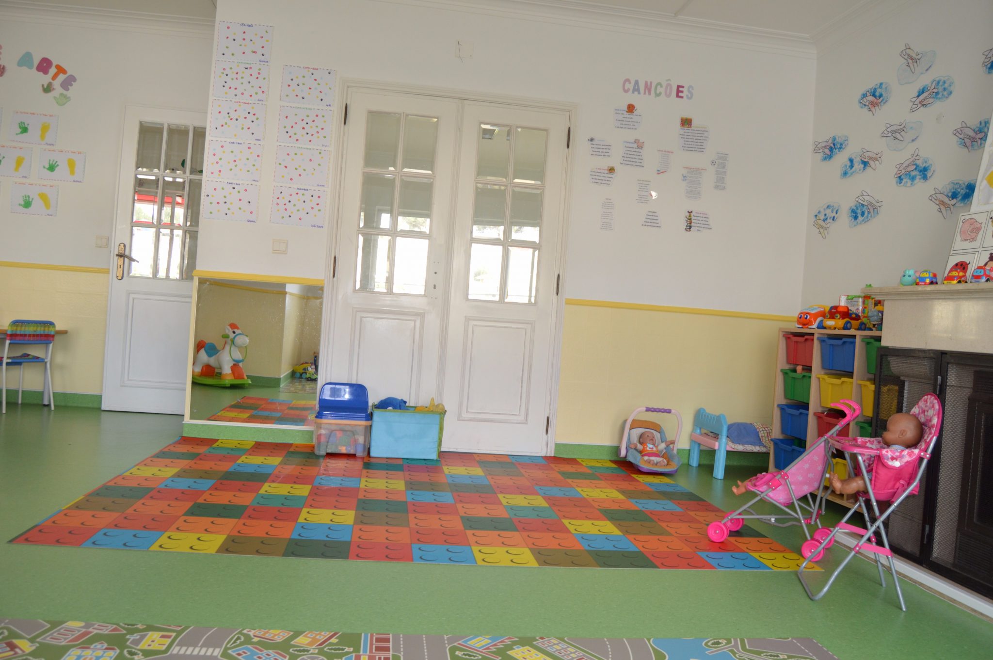 Preschool classroom with colorful floor, toys, and educational materials