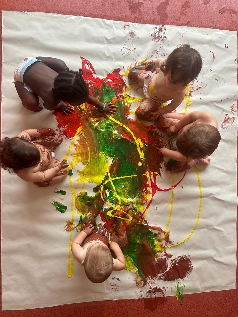 Preschool children participate in a finger painting activity, showcasing creativity and colorful artwork.
