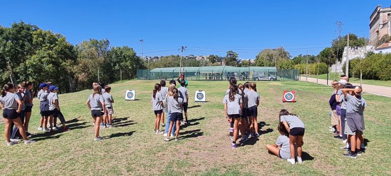 Preschool children participating in archery activities outdoors