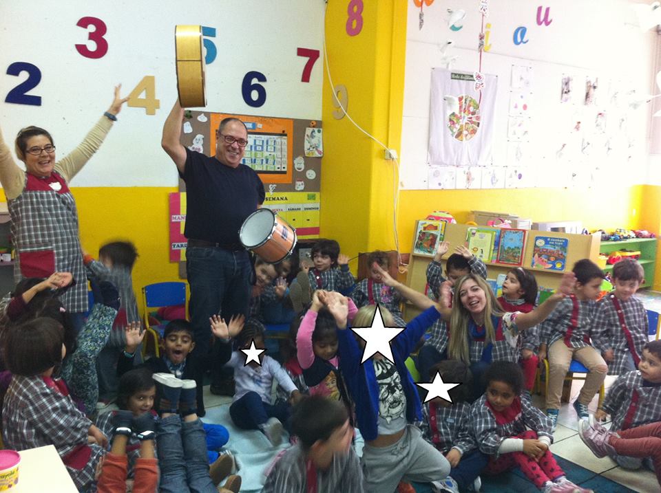 Preschool children and teachers playing music together in a classroom