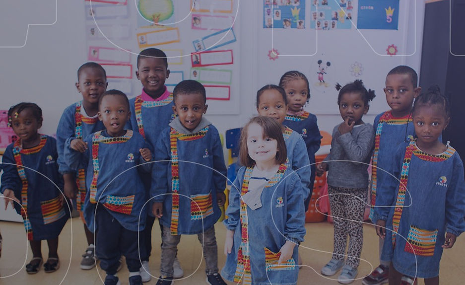 Preschool children in uniform smiling for a class photo
