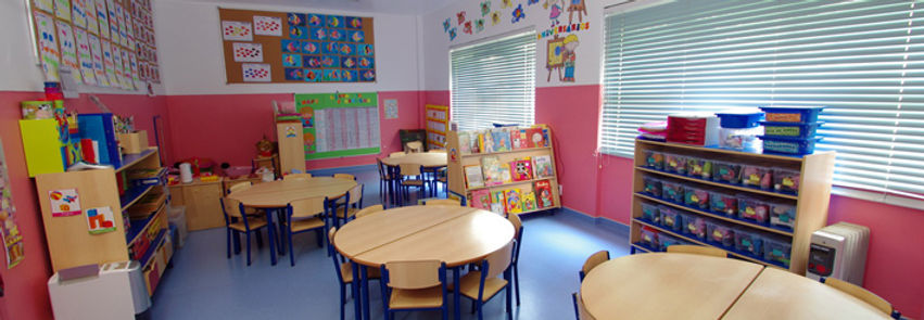 Preschool classroom with colorful furniture, books, and educational materials