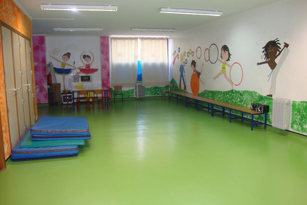 Preschool gym with green floor and colorful wall murals