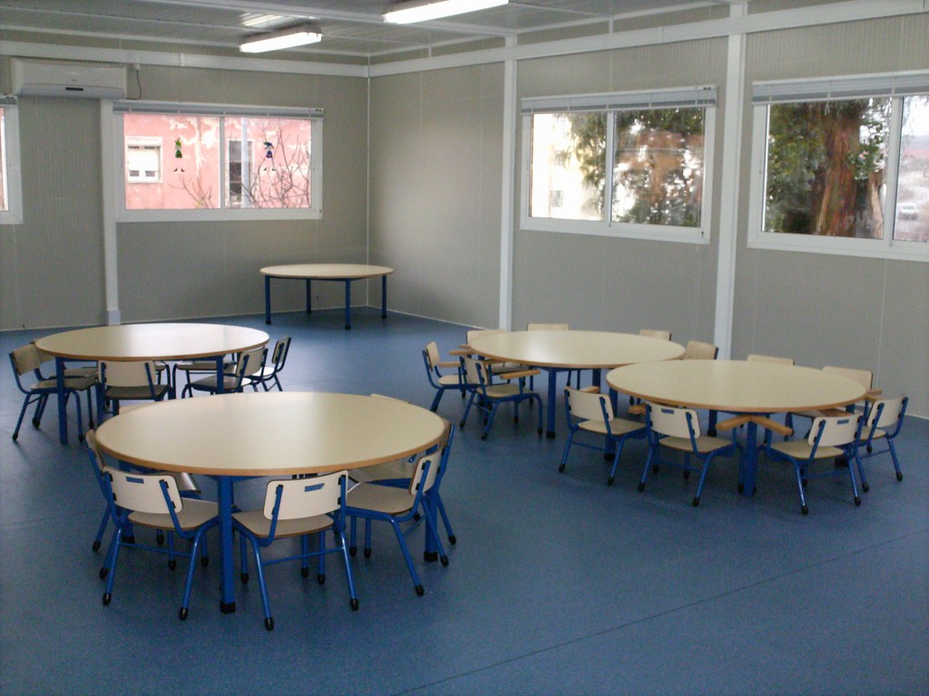 Preschool classroom with multiple small tables and chairs