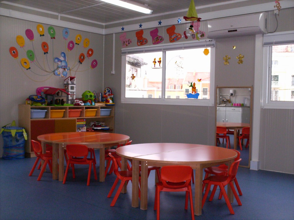 Preschool classroom with colorful tables and chairs, toys, and decorations