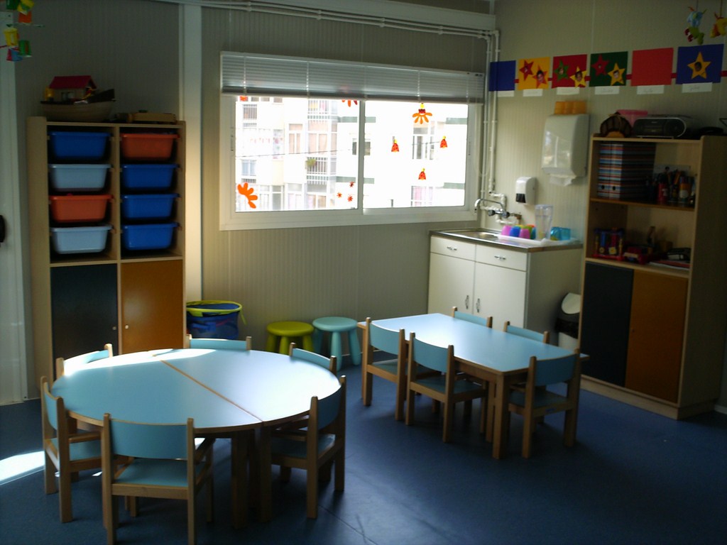 Preschool classroom with tables, chairs, and storage
