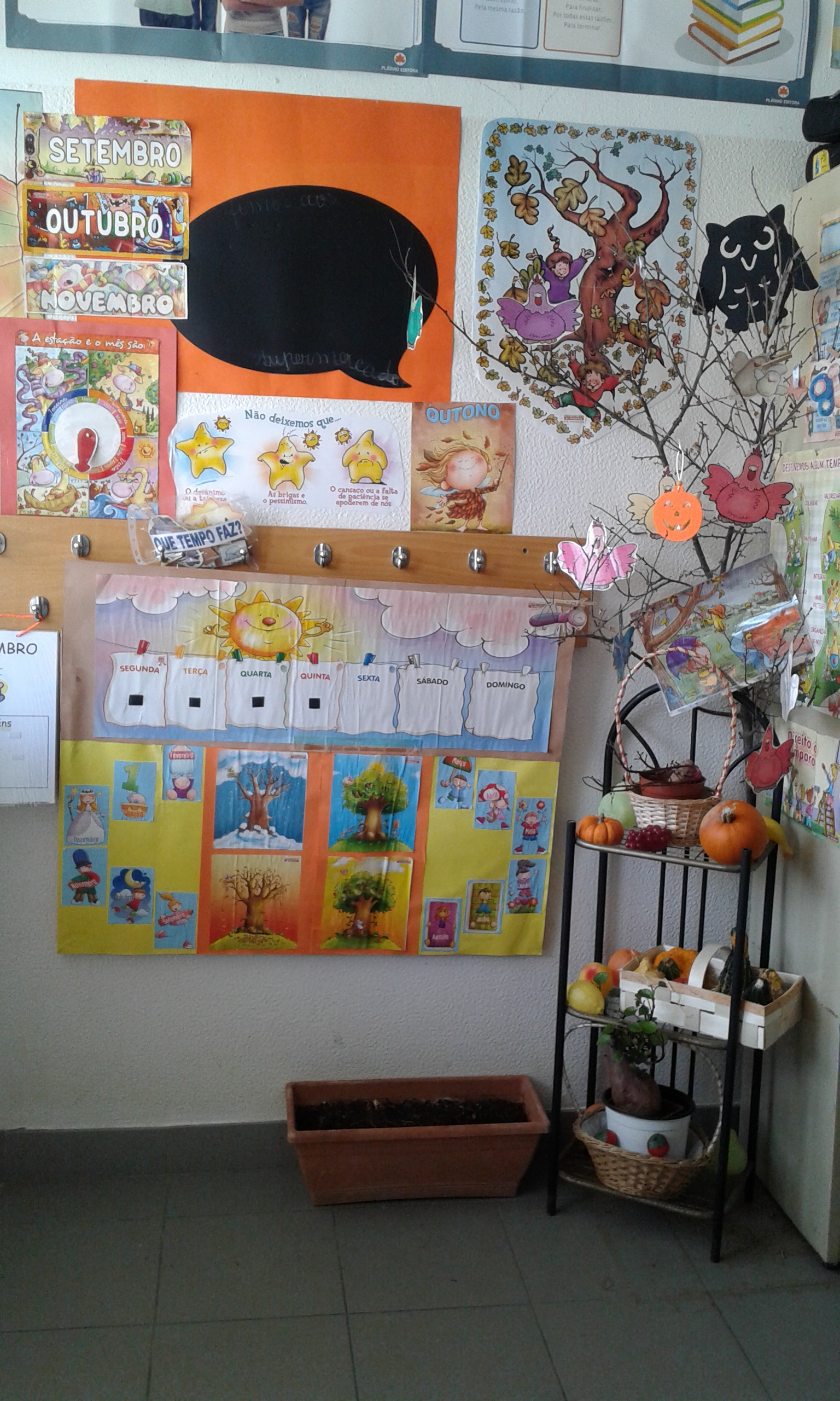 Preschool classroom decorated for autumn with educational charts and seasonal items