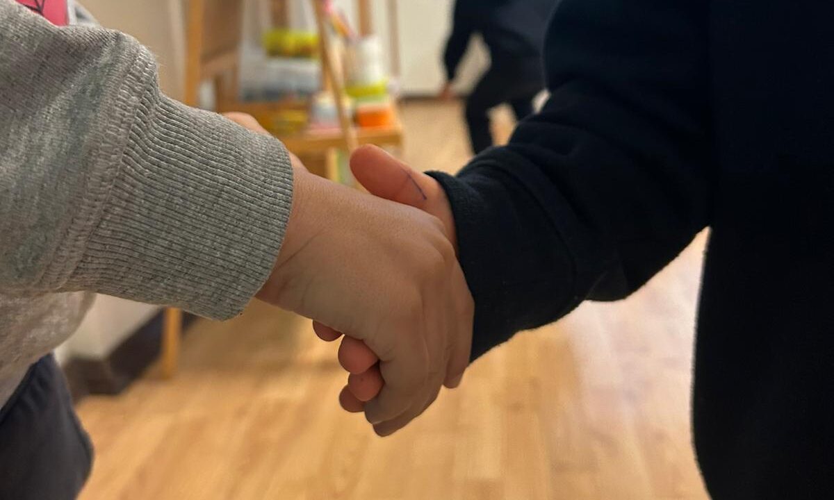 Two preschool children holding hands