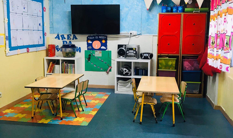 Preschool classroom with tables, chairs, and educational materials