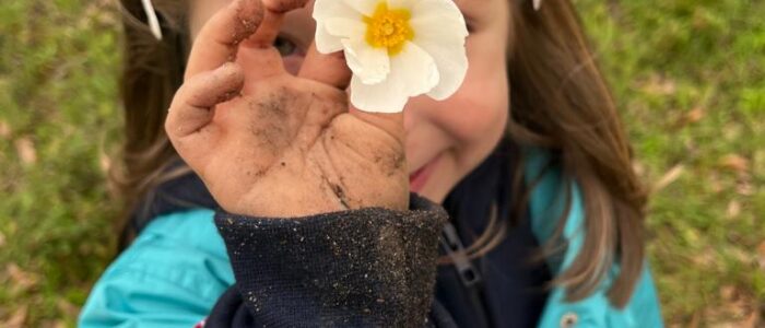 Preschool child holding a flower