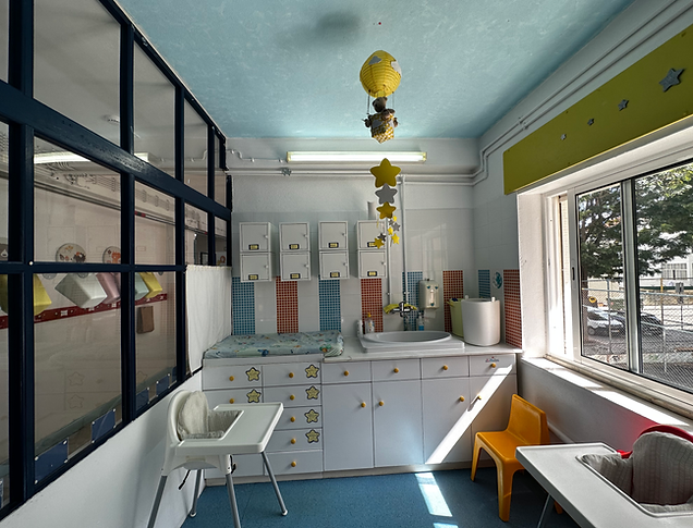Preschool baby changing room with bright colors and child-friendly furniture