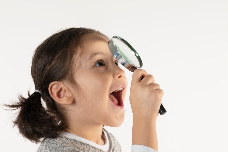Preschool child exploring with a magnifying glass