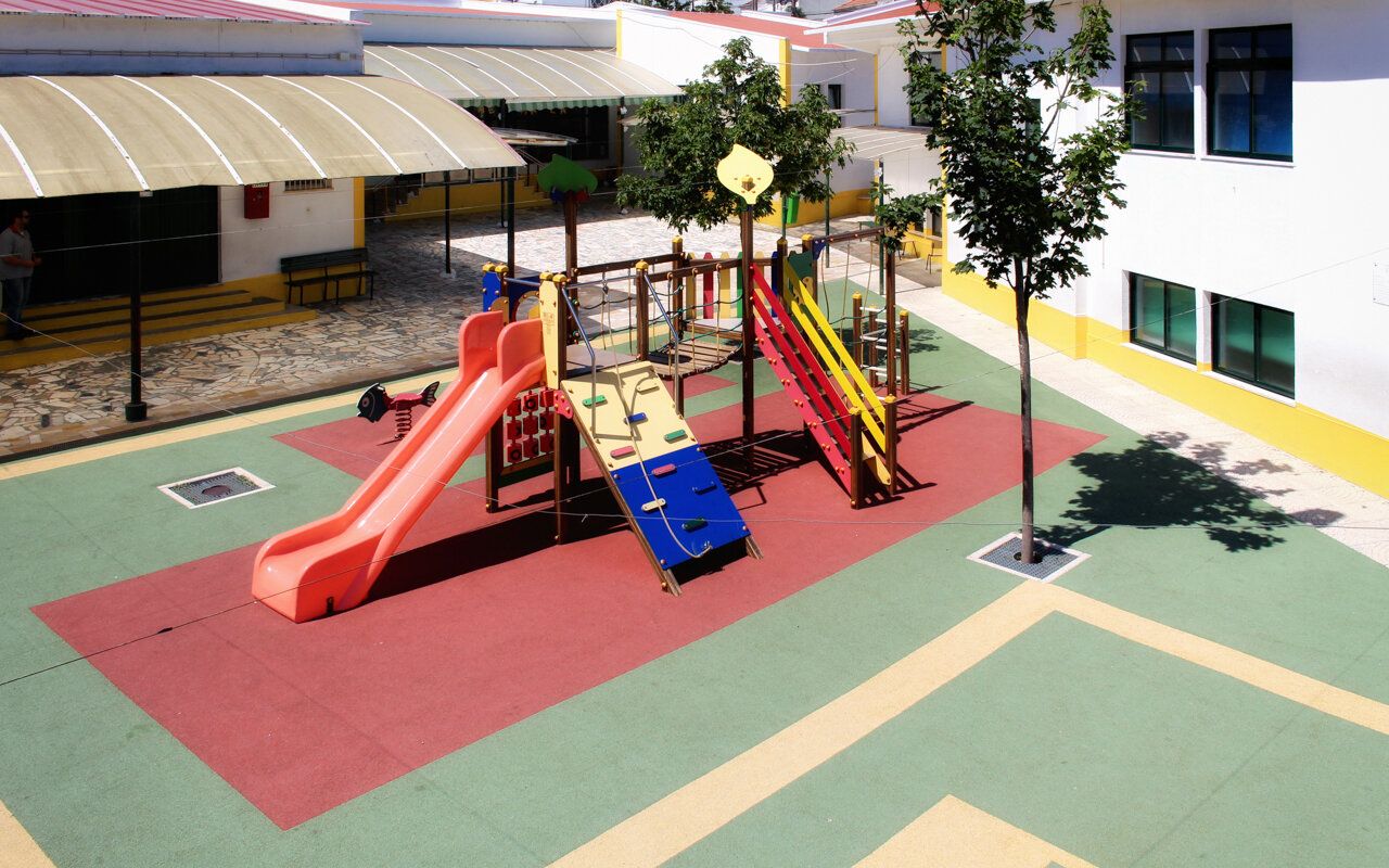 A Nossa Creche playground with colorful play equipment