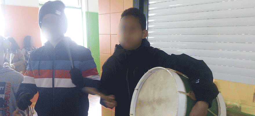 Students playing traditional Portuguese drum inside school
