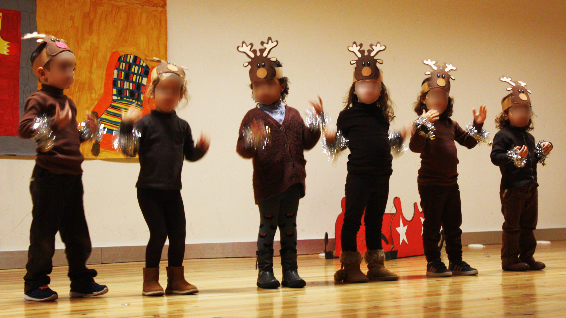 Preschool children in reindeer costumes performing on stage