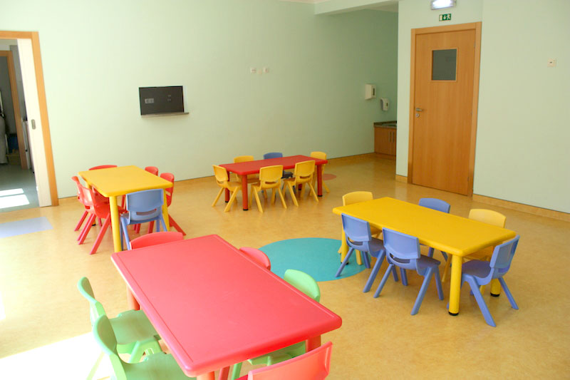 Preschool classroom with colorful tables and chairs