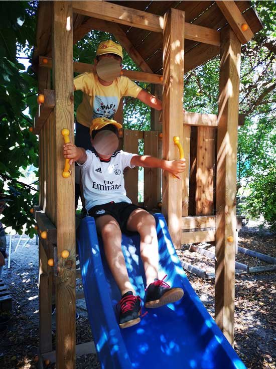 Preschool children playing on a slide at A Casinha Mágica