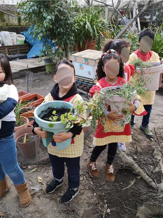 Preschool children participating in gardening activities at A Casinha Mágica.