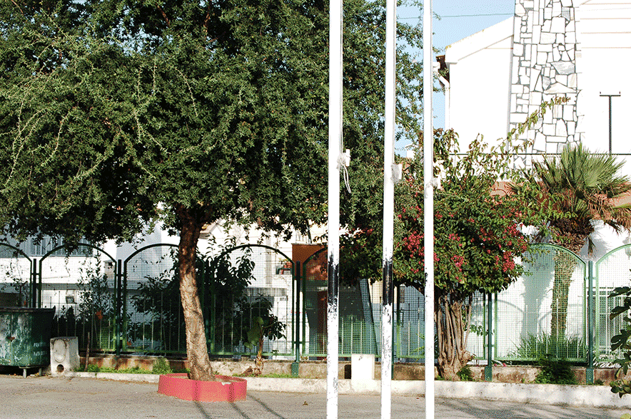 Exterior view of Jardim de Infância da Quinta da Princesa, showing trees, shrubs, and a section of the school building.
