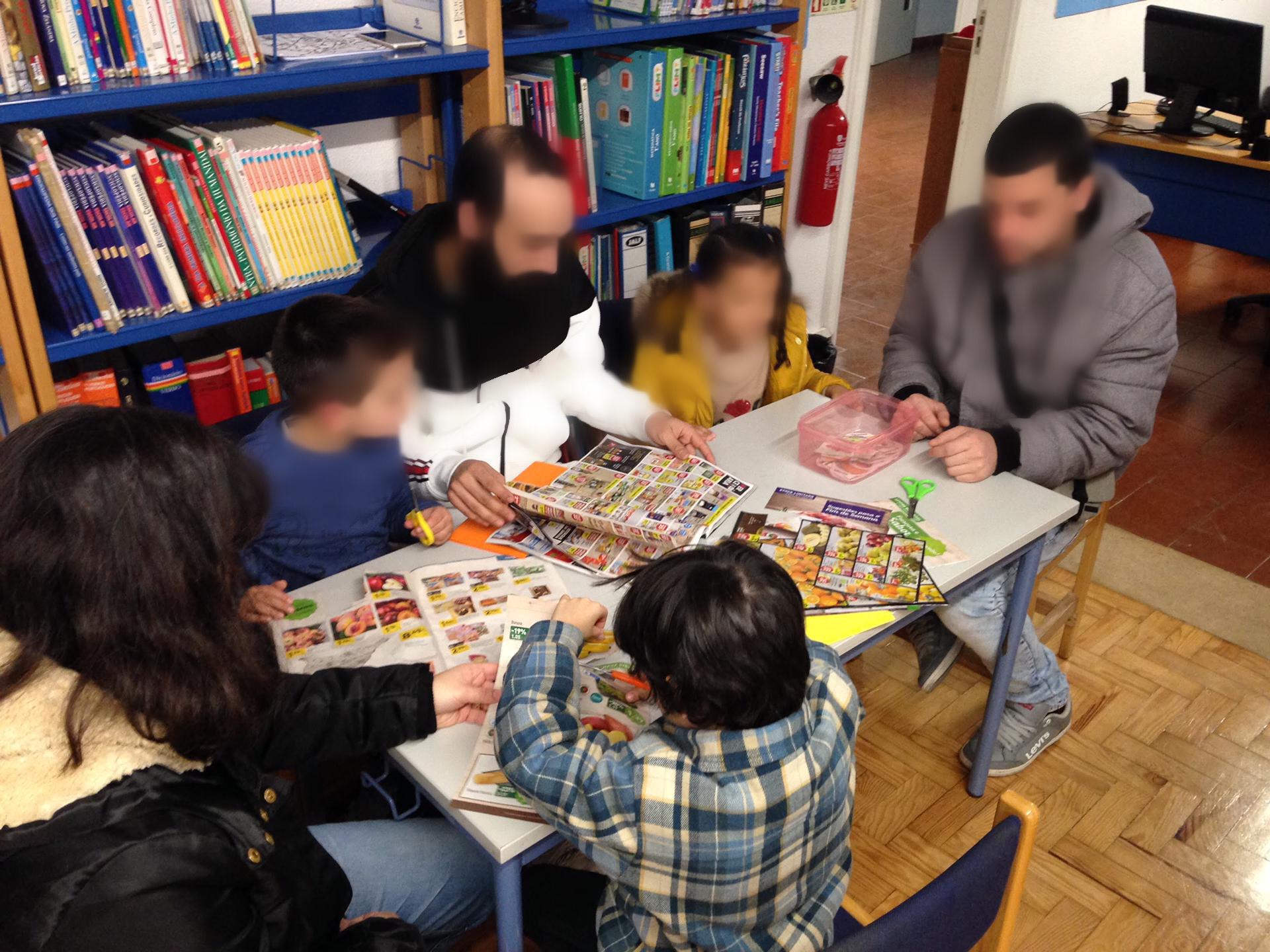 Preschool children participate in a classroom activity using magazines and scissors.