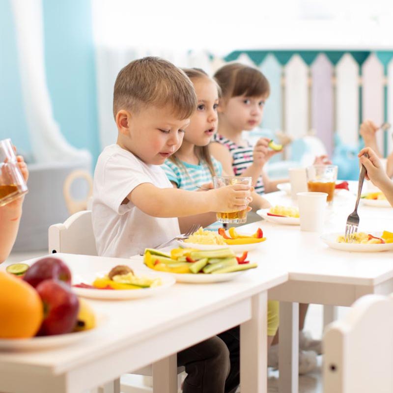 Preschool children enjoying a healthy meal together at a table