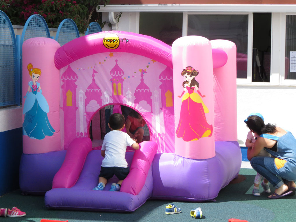 Preschool children playing in a pink inflatable castle bounce house