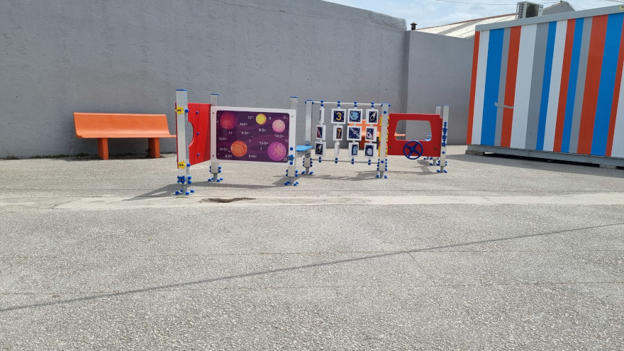 Preschool playground equipment with colorful panels featuring planets and numbers