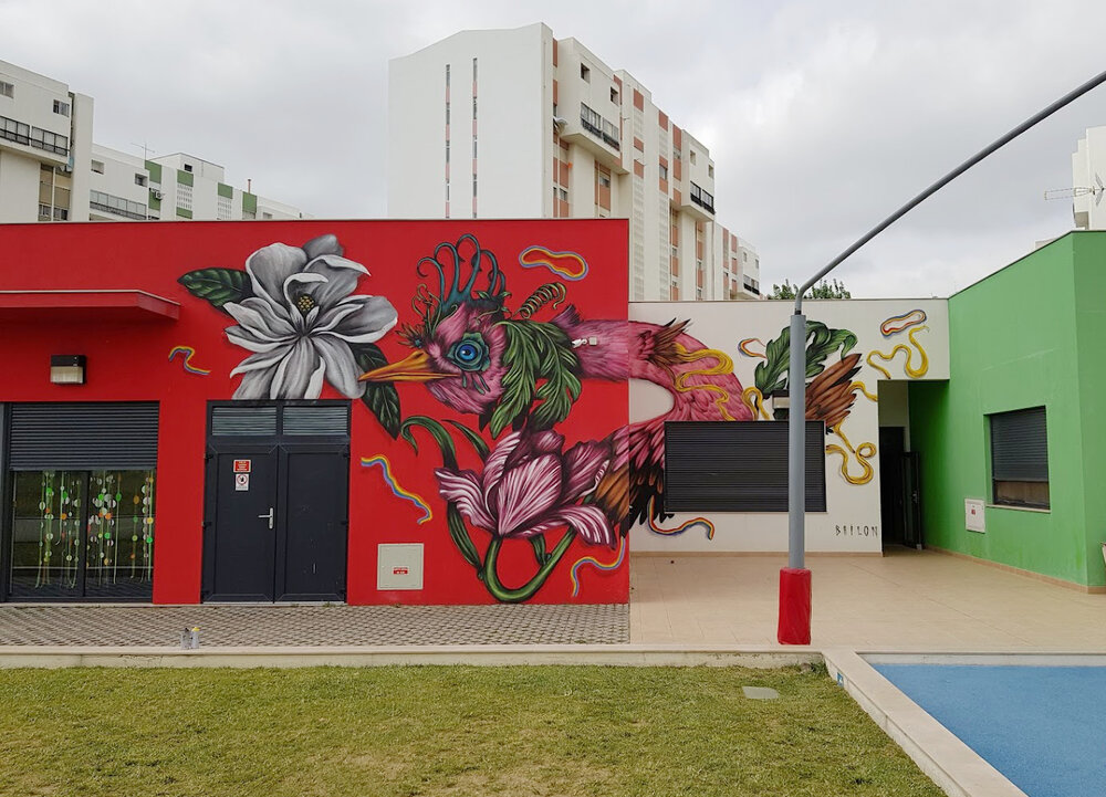 Colorful bird and flower mural on the exterior wall of a preschool building