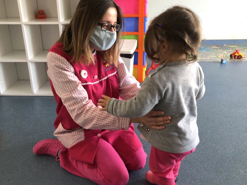 Teacher comforting a preschooler at The Cachoeirinhos Nursery and Kindergarten