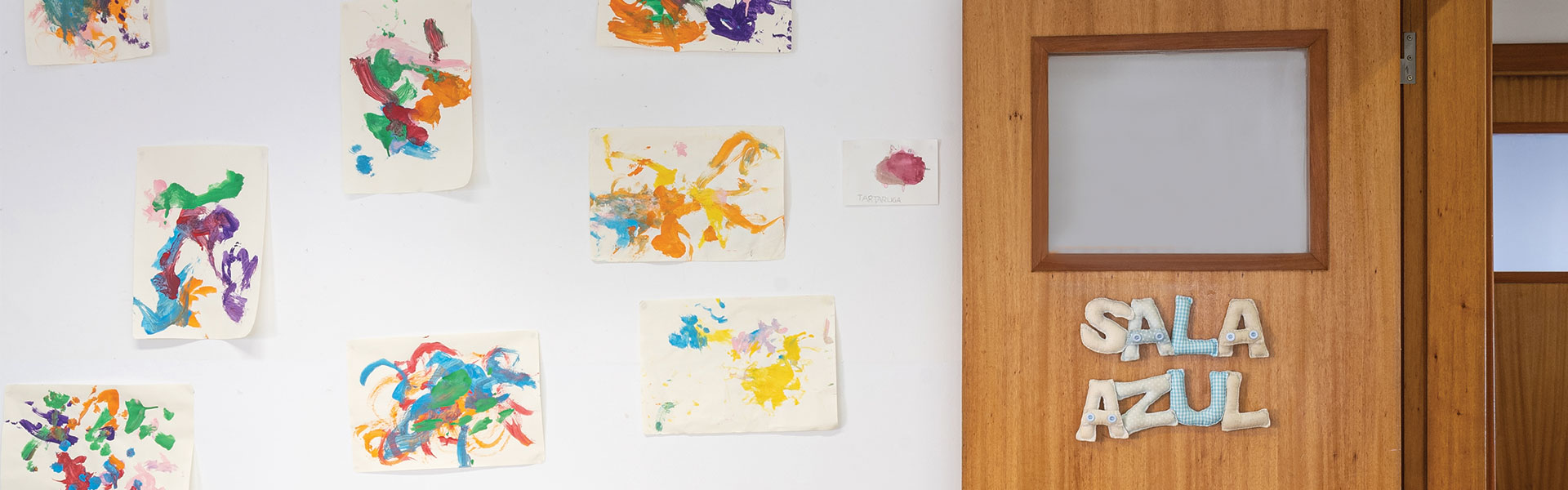 Preschool classroom wall decorated with colorful children's artwork