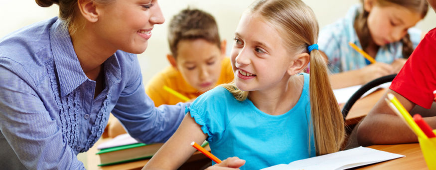 Preschool teacher assisting student with classwork