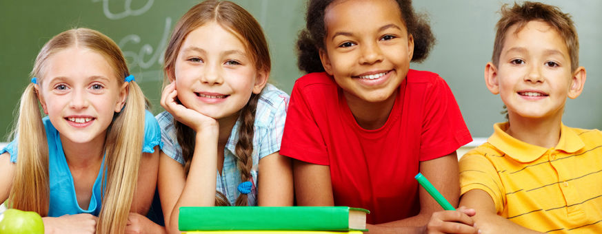 Happy diverse group of preschool children smiling and learning together in a classroom