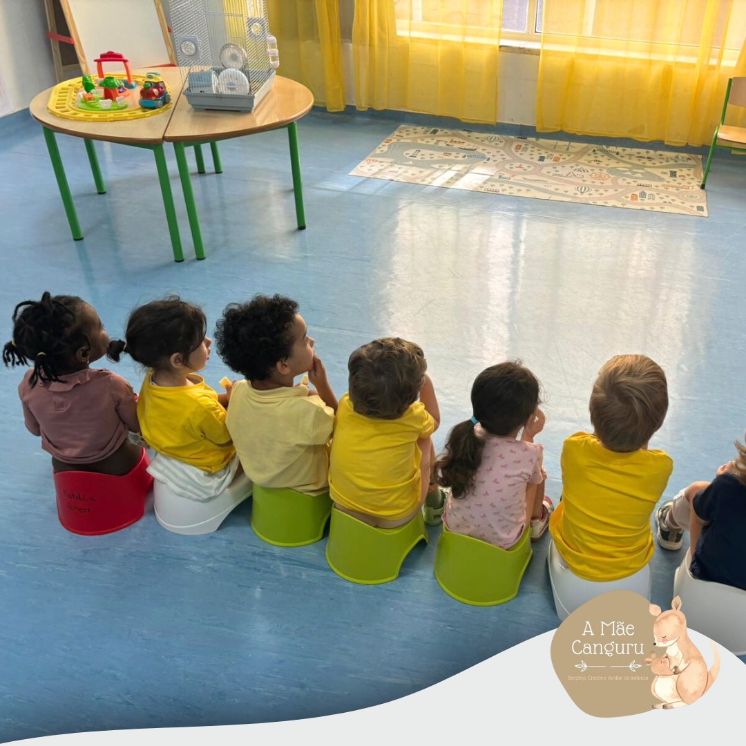 Preschool children sitting on potty chairs in a classroom