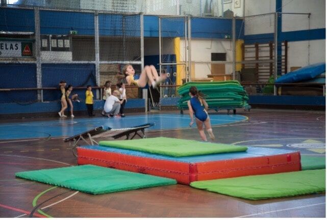 Preschool children performing gymnastics in a gymnasium