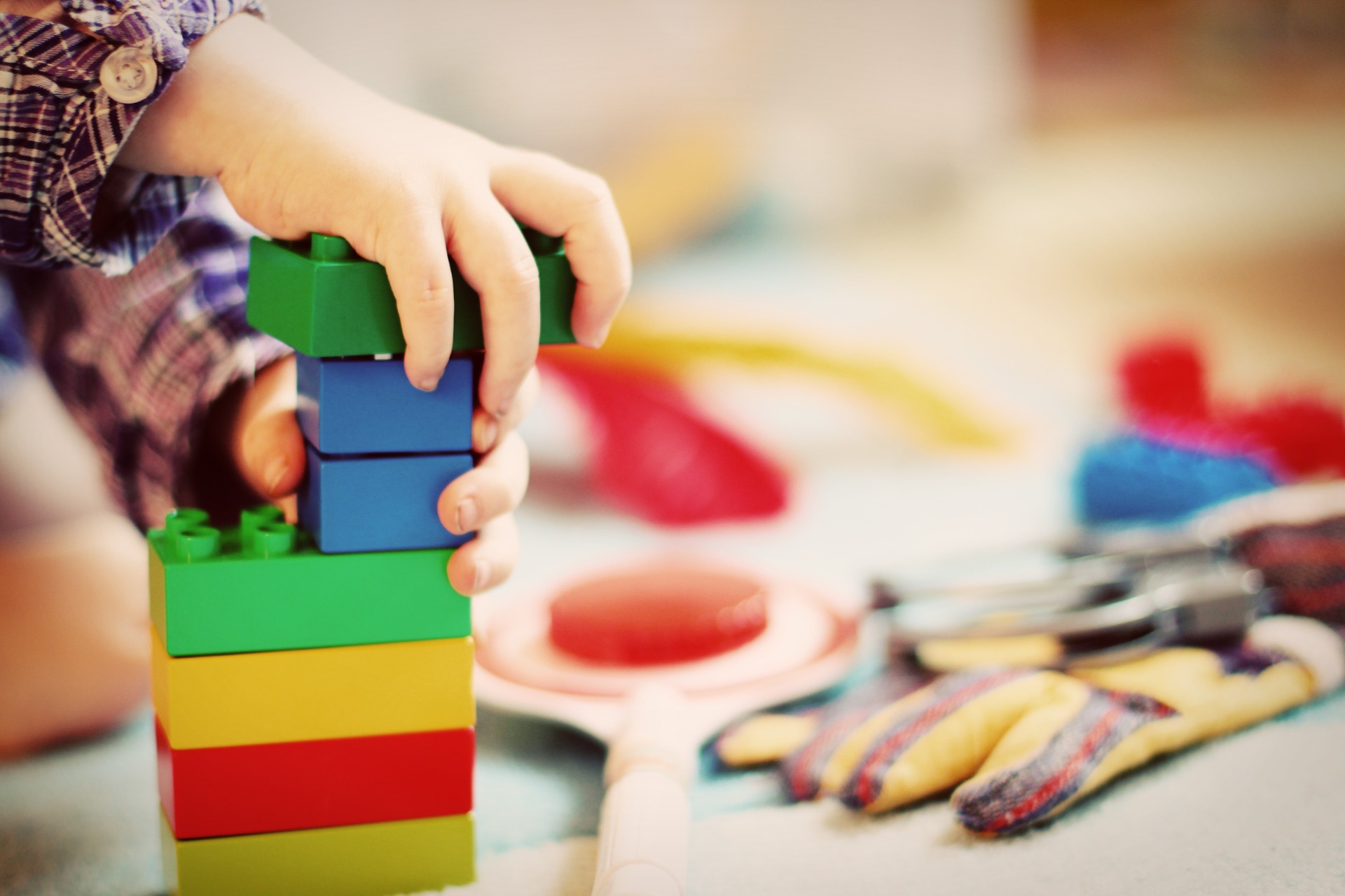 Child playing with colorful Lego blocks